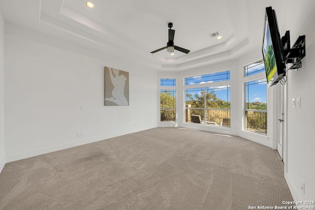 unfurnished room with light carpet, a raised ceiling, and ceiling fan