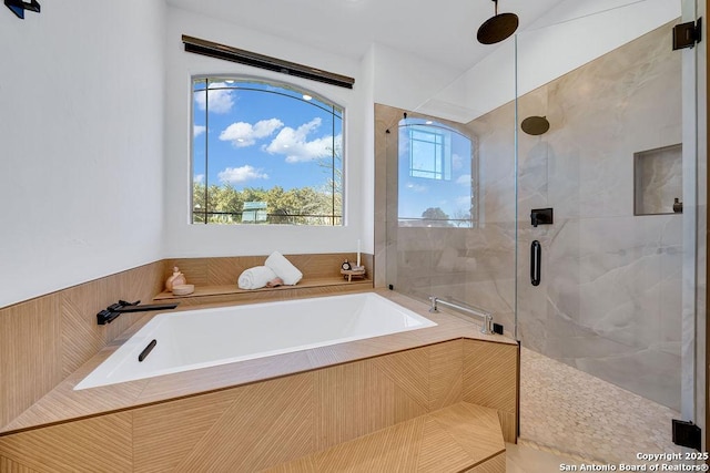 bathroom featuring independent shower and bath