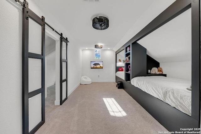 carpeted bedroom with a barn door