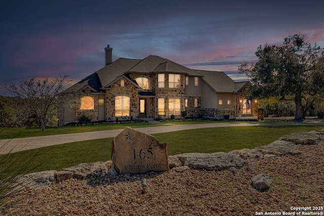 french provincial home with a lawn