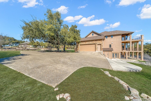 view of front of house with a balcony, a garage, and a front lawn