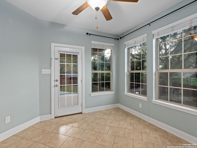 unfurnished sunroom featuring ceiling fan