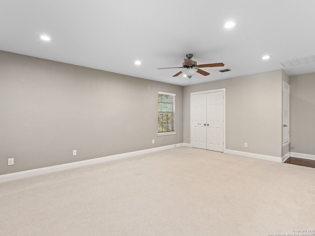 spare room with ceiling fan and light carpet