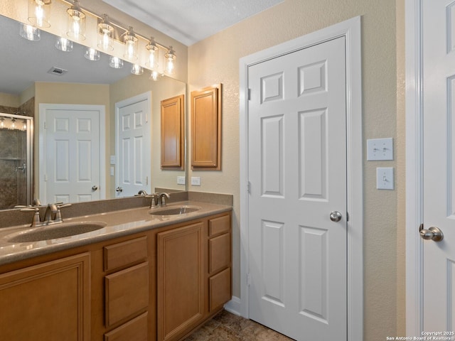 bathroom featuring vanity and a shower with shower door