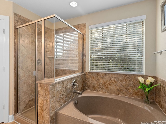 bathroom featuring plenty of natural light and independent shower and bath