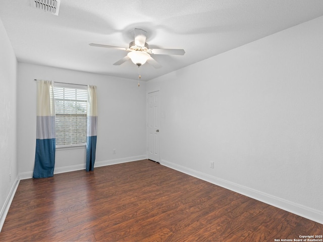 unfurnished room featuring dark wood-type flooring and ceiling fan