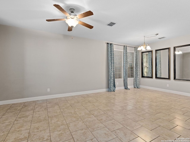 spare room featuring ceiling fan with notable chandelier