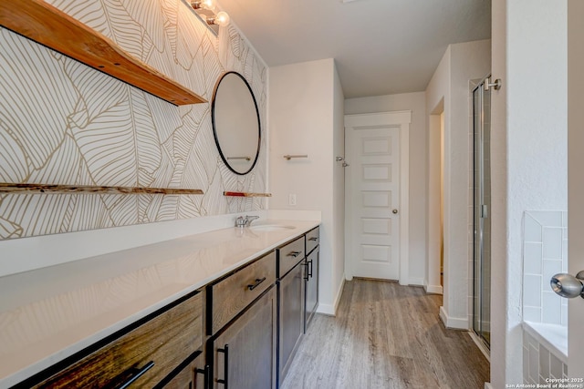 bathroom with wood-type flooring, vanity, and walk in shower