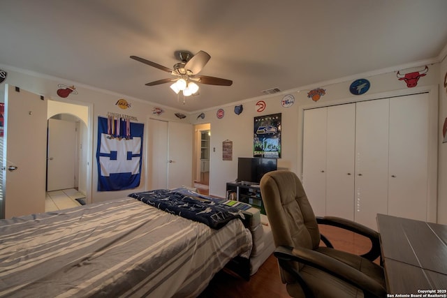 bedroom with crown molding, ceiling fan, and a closet