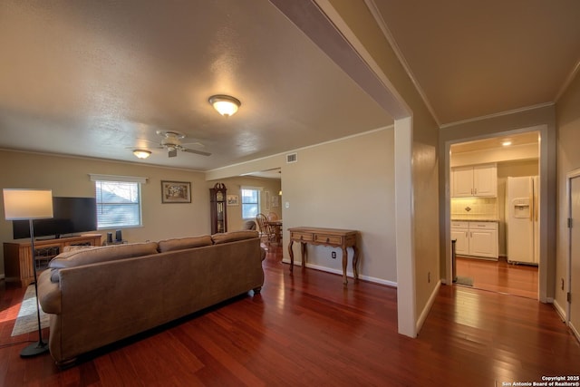 living room featuring dark wood-type flooring, ceiling fan, and ornamental molding