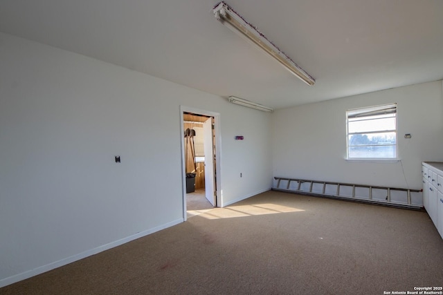 carpeted spare room featuring a baseboard radiator