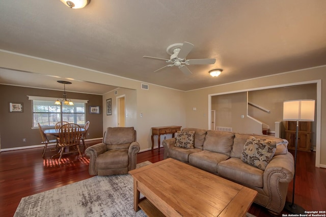 living room featuring dark wood-type flooring and ceiling fan with notable chandelier