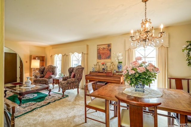 carpeted dining room featuring a notable chandelier