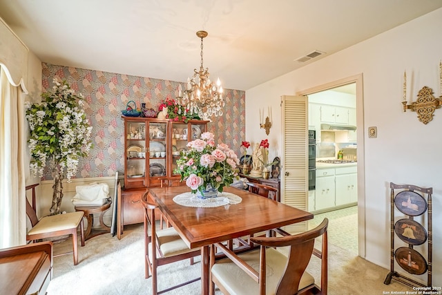 carpeted dining space featuring a chandelier