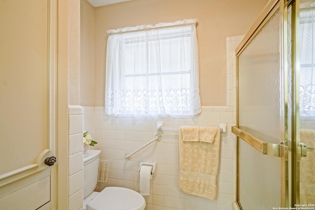 bathroom with tile walls, an enclosed shower, and toilet