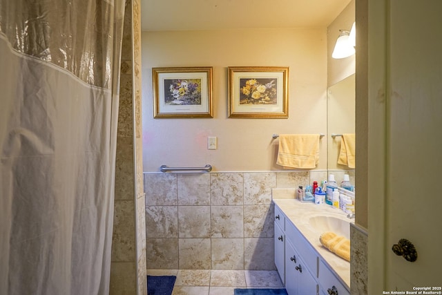 bathroom with tile walls, vanity, and walk in shower