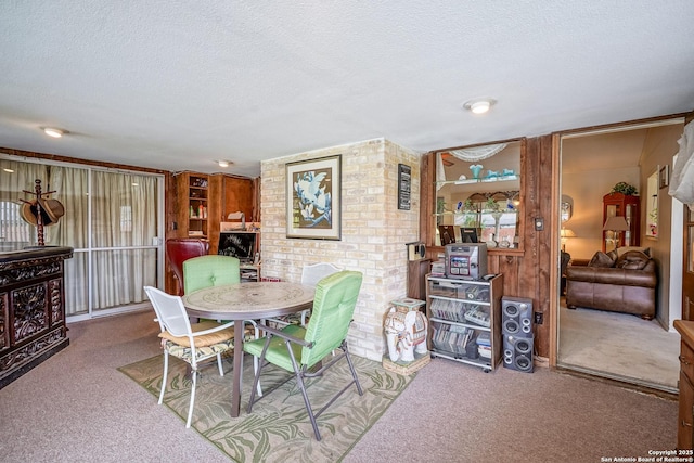 dining area featuring light colored carpet and a textured ceiling