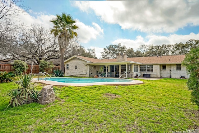 rear view of house featuring a fenced in pool, a patio, a yard, and cooling unit