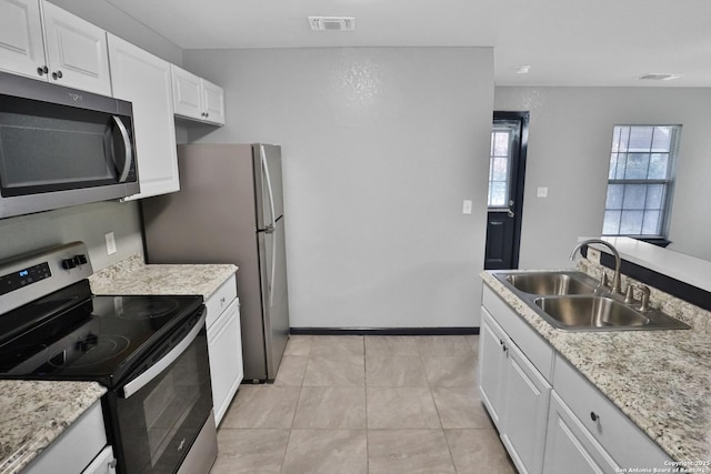 kitchen featuring white cabinetry, sink, light tile patterned floors, and stainless steel appliances