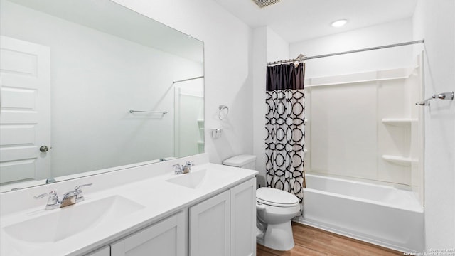 full bathroom featuring vanity, hardwood / wood-style floors, toilet, and shower / bath combo