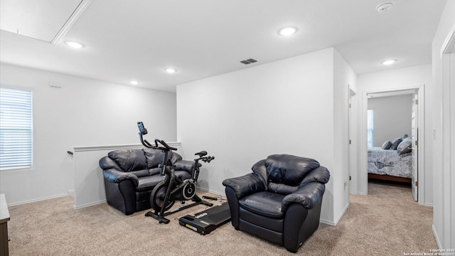 living area with a wealth of natural light and light colored carpet