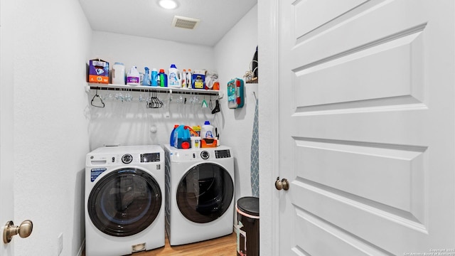 laundry room featuring separate washer and dryer and light hardwood / wood-style floors