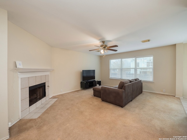 living room featuring ceiling fan, light colored carpet, and a tiled fireplace