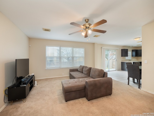 carpeted living room with ceiling fan