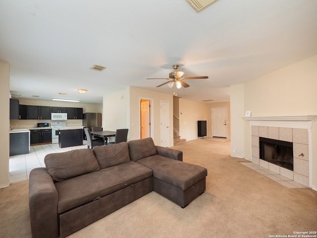 carpeted living room featuring ceiling fan and a fireplace