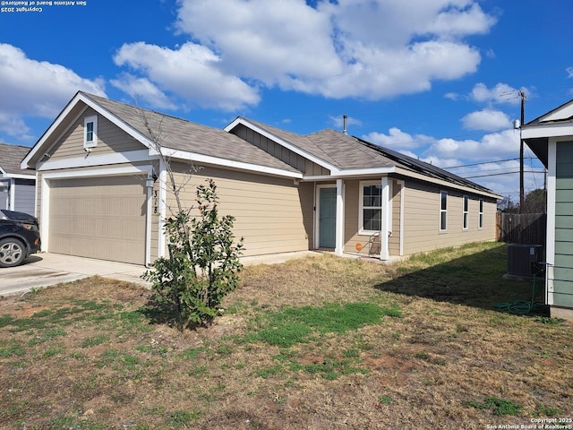 view of front of home featuring a garage and central air condition unit