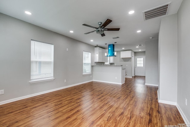 unfurnished living room with hardwood / wood-style flooring and ceiling fan