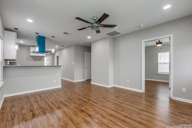 unfurnished living room featuring ceiling fan and wood-type flooring