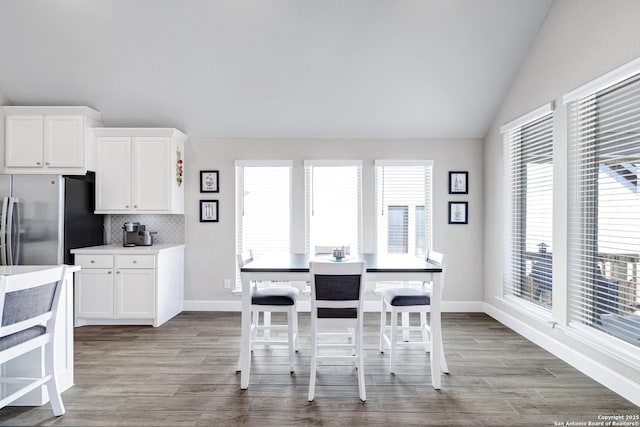 dining space featuring lofted ceiling and wood-type flooring