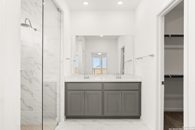 bathroom with vanity and a tile shower