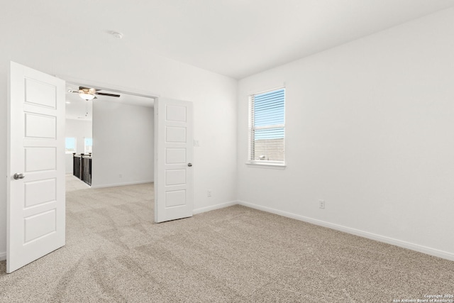 carpeted spare room with ceiling fan