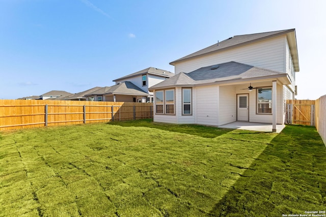 rear view of house featuring ceiling fan, a yard, and a patio