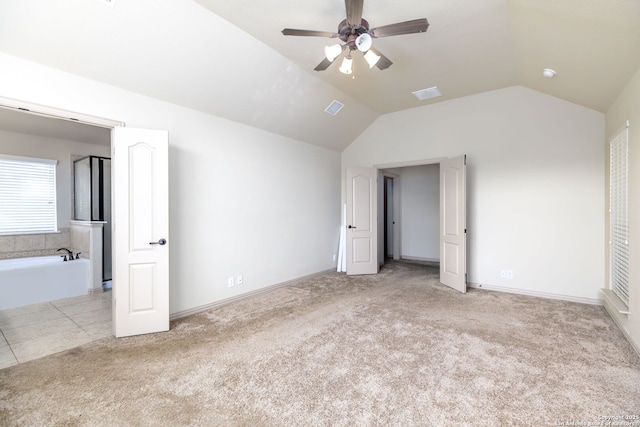 unfurnished bedroom featuring light carpet, lofted ceiling, and ceiling fan