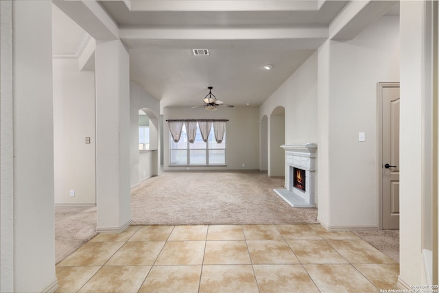 unfurnished living room featuring light carpet and ceiling fan