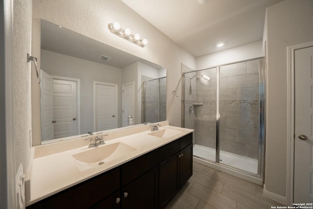 bathroom featuring vanity, a shower with shower door, and tile patterned flooring