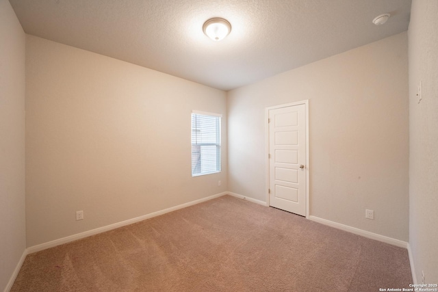 carpeted empty room with a textured ceiling