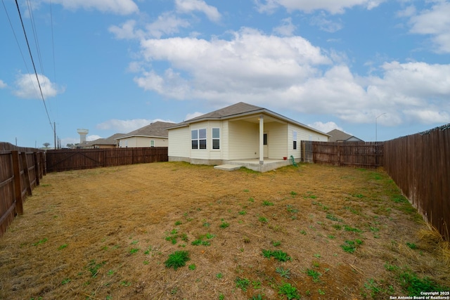 rear view of house featuring a lawn and a patio