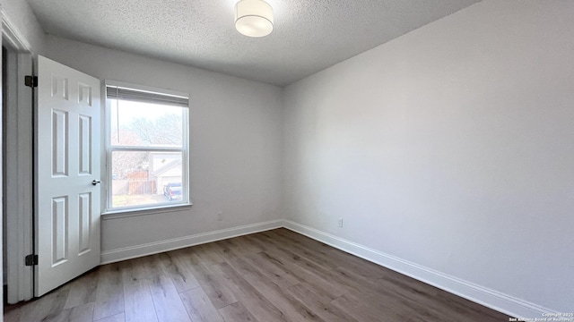 unfurnished room with light hardwood / wood-style flooring and a textured ceiling