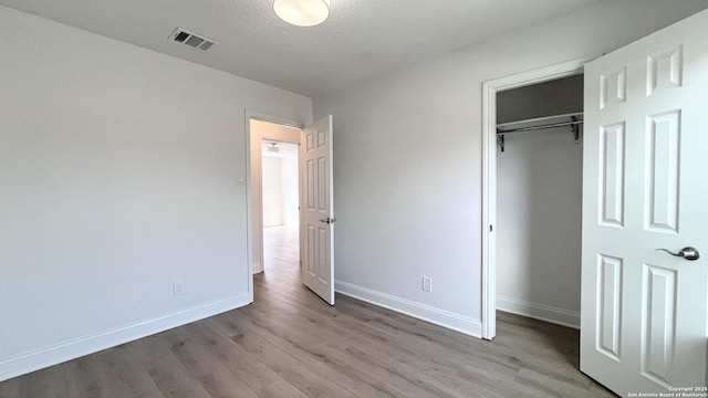 unfurnished bedroom with light hardwood / wood-style flooring and a closet