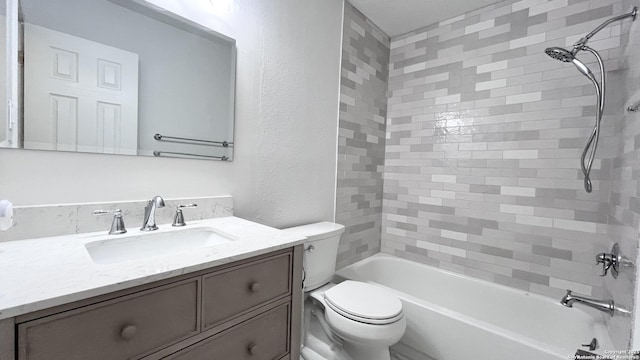 full bathroom featuring tiled shower / bath combo, vanity, and toilet