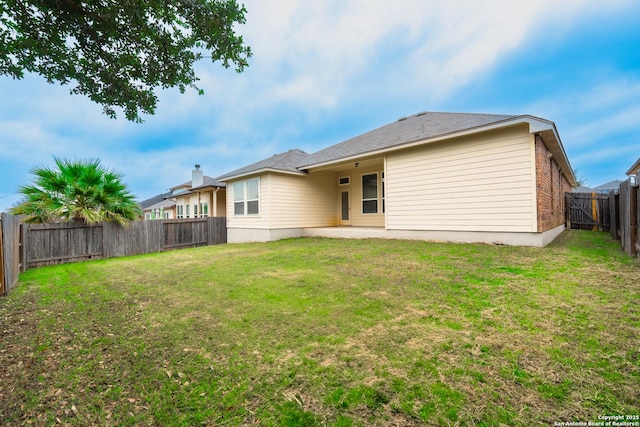 back of house featuring a lawn and a patio