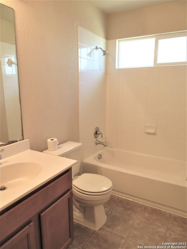 full bathroom featuring vanity, tile patterned floors, toilet, and tiled shower / bath