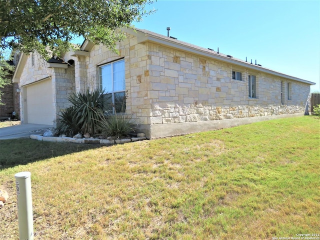 view of side of home featuring a garage and a lawn