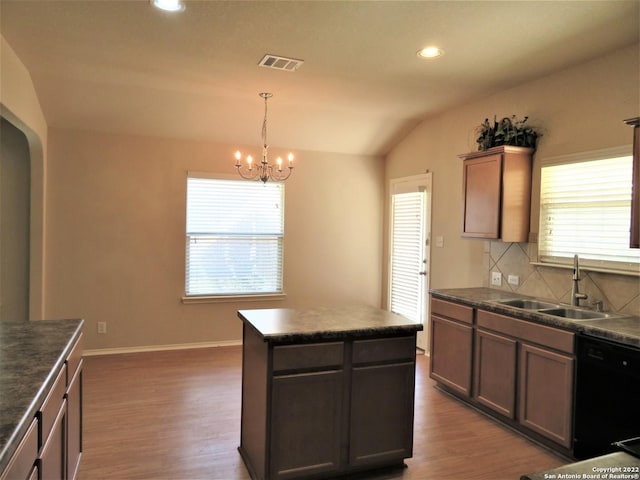 kitchen featuring a kitchen island, dishwasher, sink, backsplash, and dark wood-type flooring