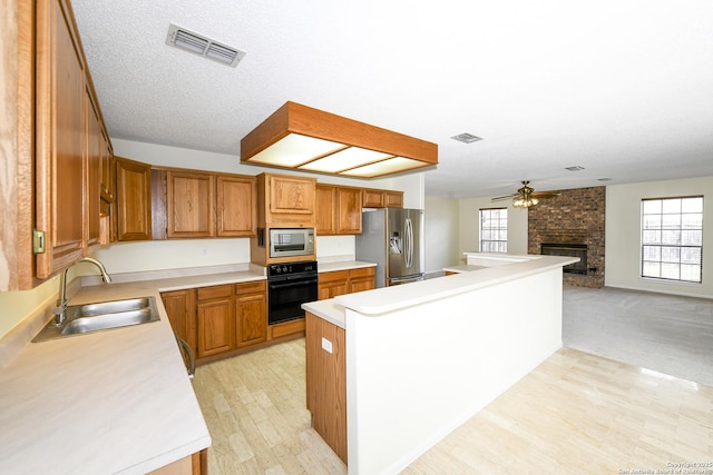 kitchen featuring sink, ceiling fan, stainless steel appliances, a healthy amount of sunlight, and a kitchen island