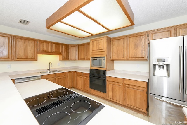 kitchen featuring appliances with stainless steel finishes, sink, and a textured ceiling